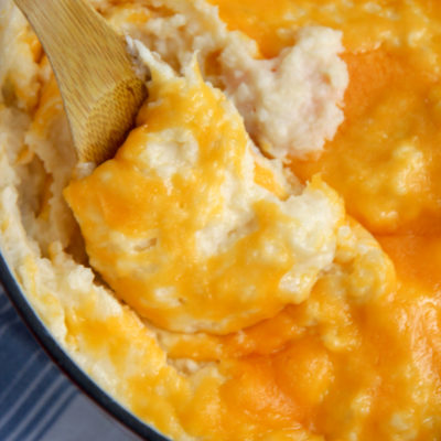 cheddar mashed with a wooden spoon and blue and white table cloth