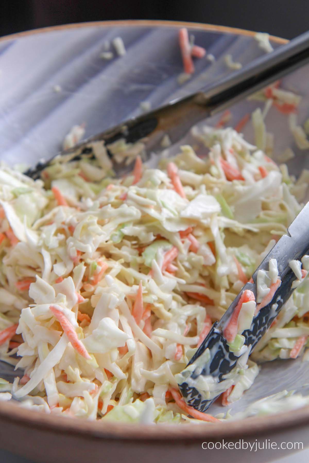 coleslaw in a bowl with tongs