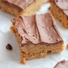 scotcharoos on parchment paper with chocolate chips and butterscotch chips