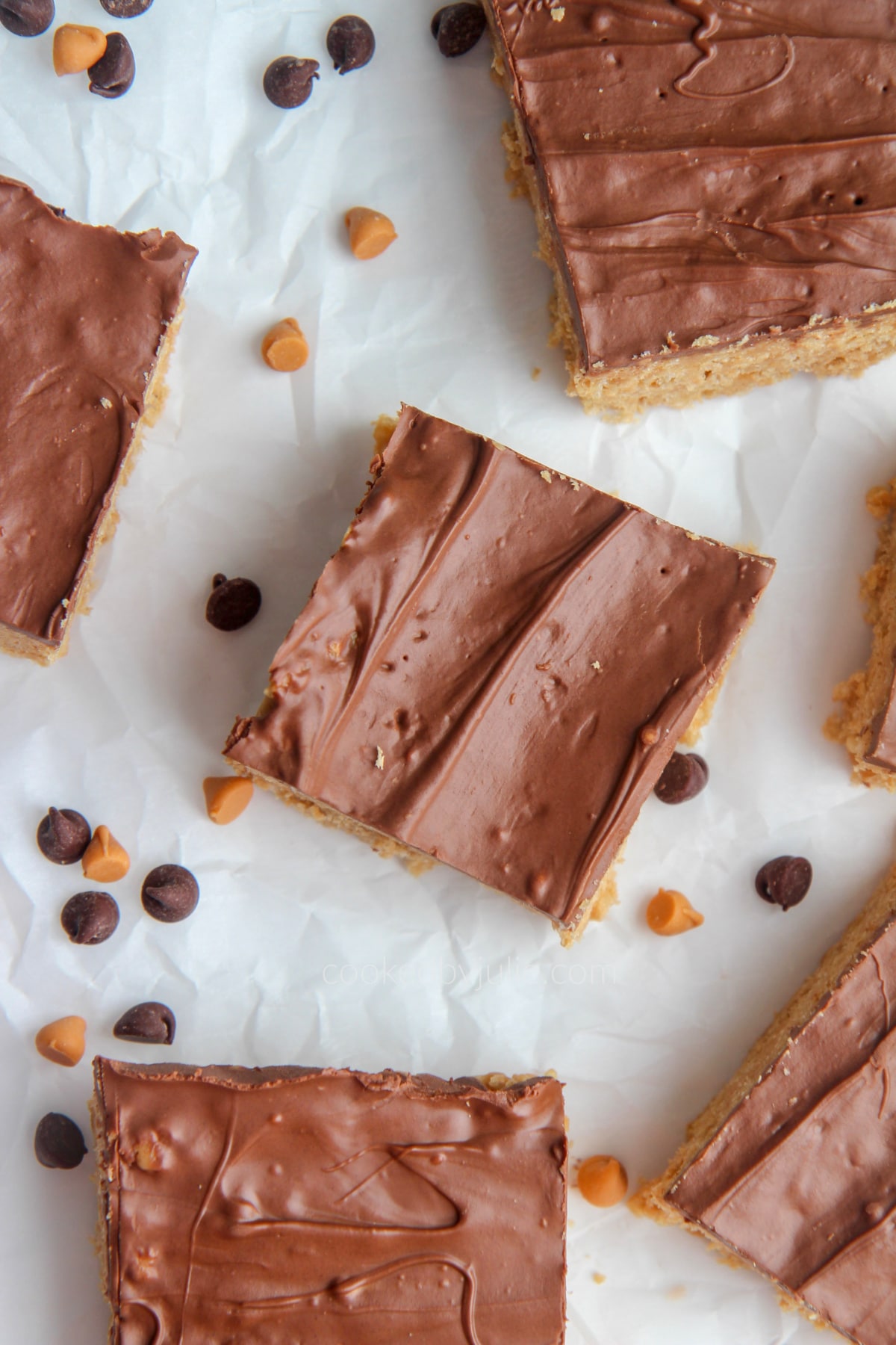 scotcharoo slices on parchment paper with chocolate chips and butterscotch chips