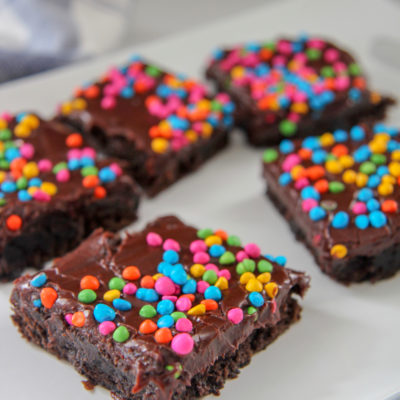 brownies with rainbow chips on top of a white plate