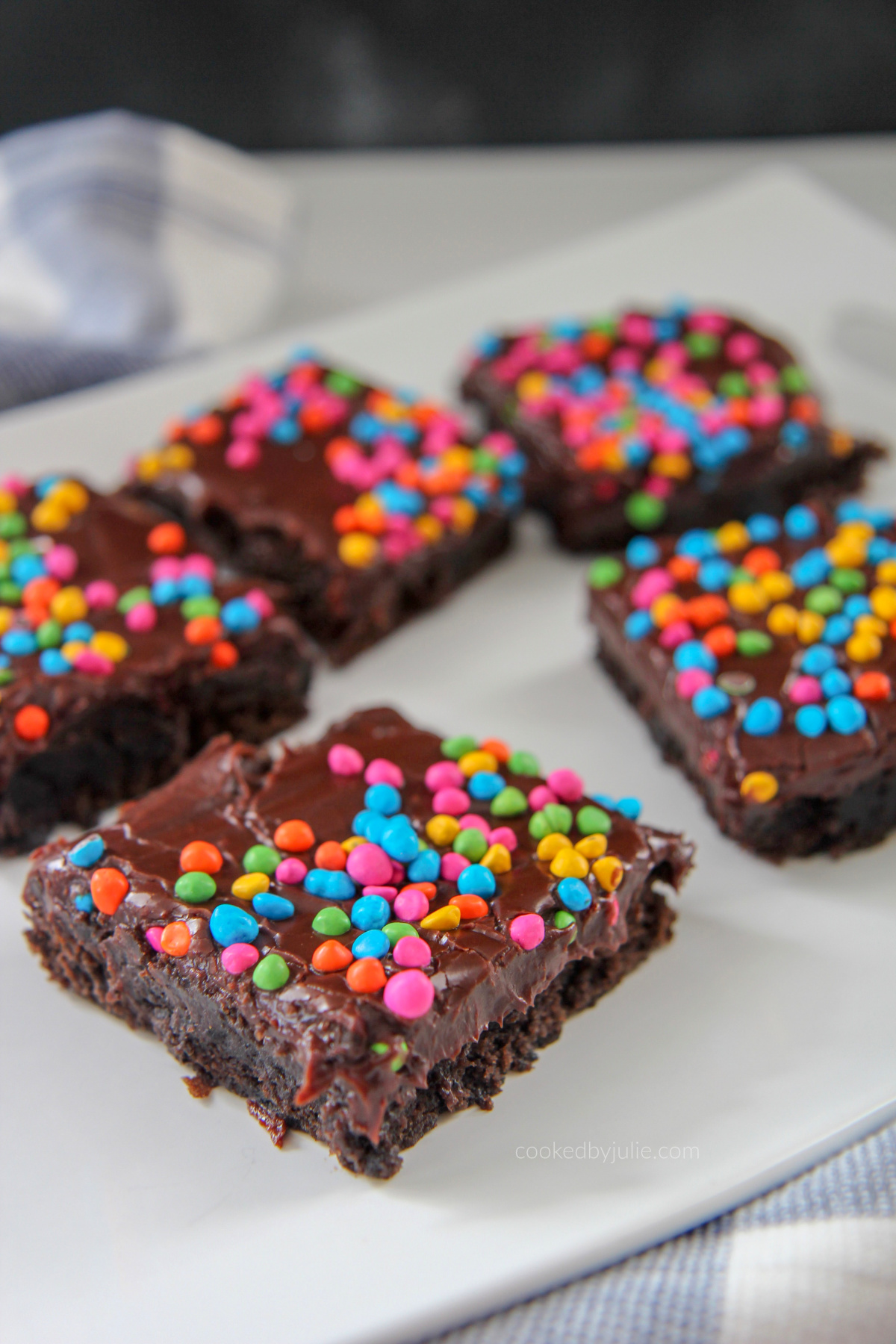 brownies with rainbow chips on top of a white plate 