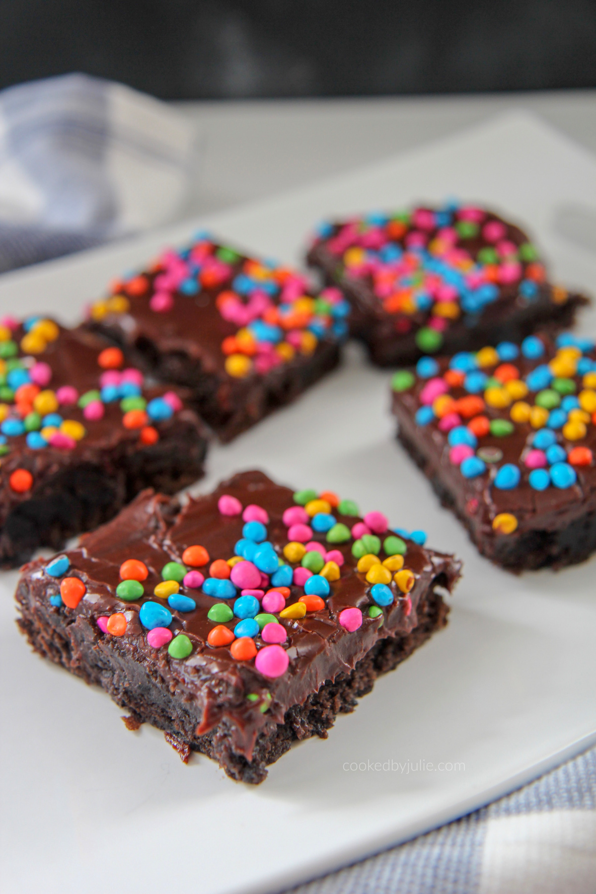 brownies with rainbow chips on top of a white plate