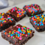 cosmic brownies with rainbow chips on a white plate