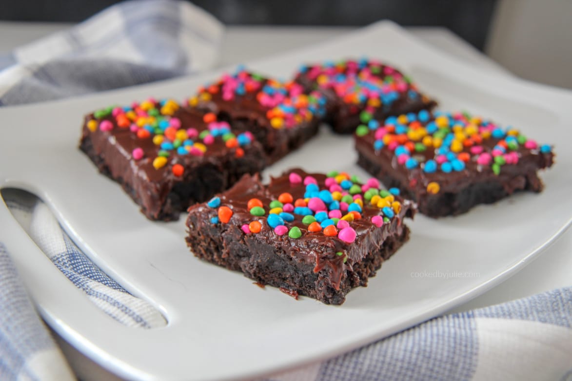 cosmic brownies on a white plate with a blue and white towel on the side 