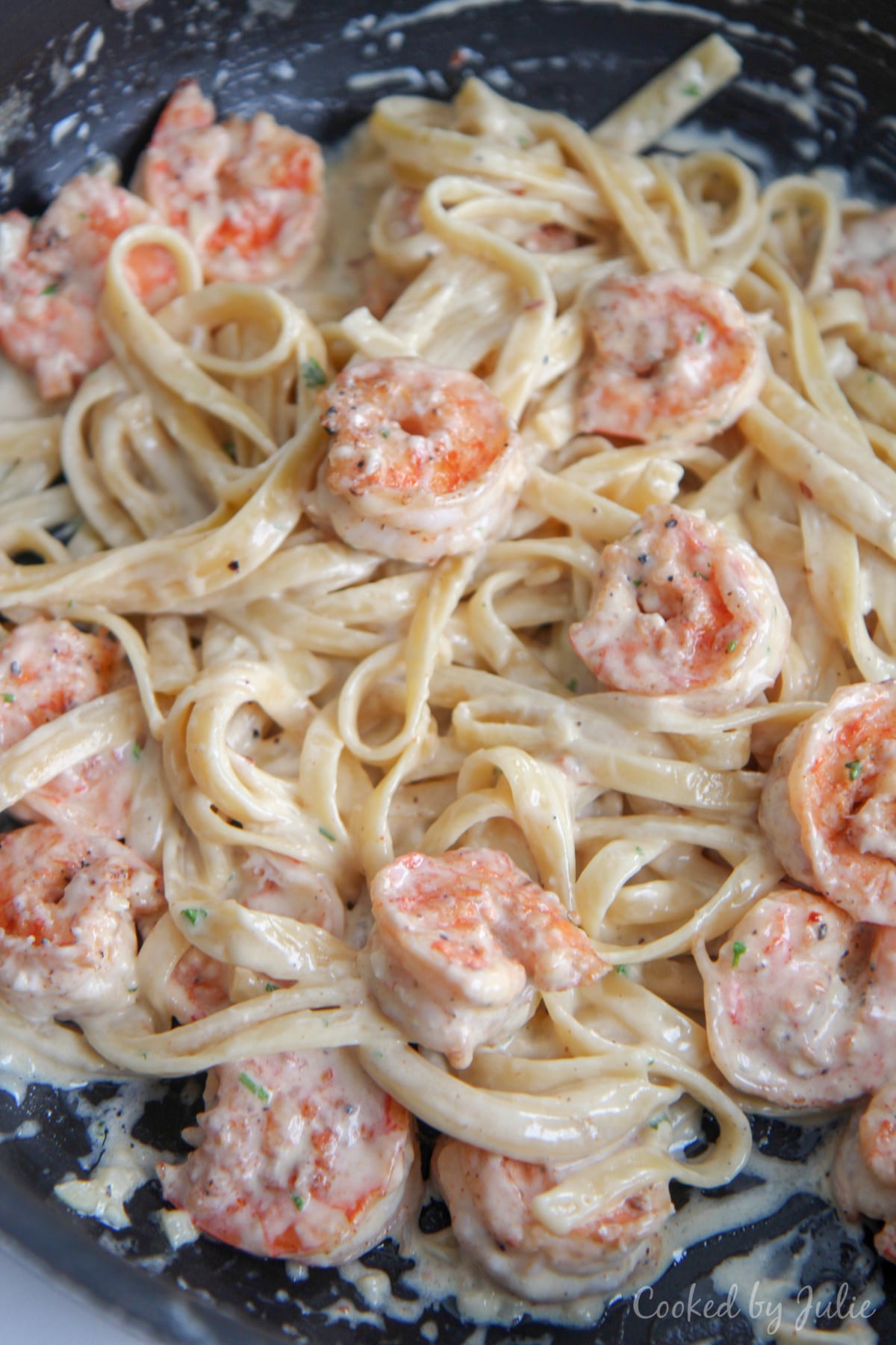 shrimp and fettuccine alfredo pasta tossed in a black skillet