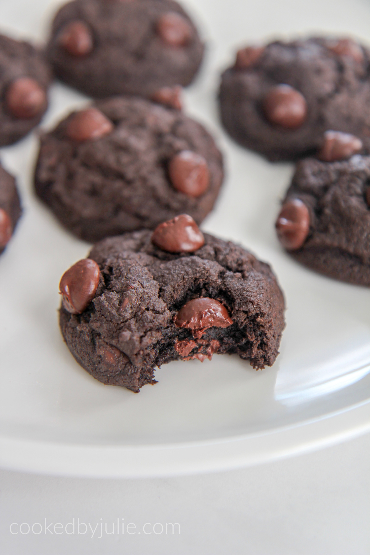 chocolate cookie bitten into on a white plate