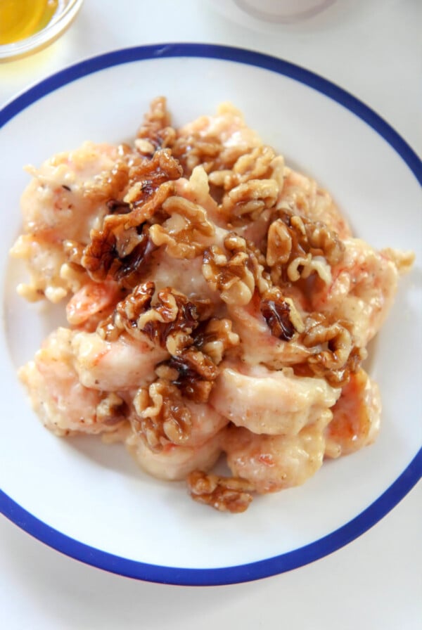 honey walnut shrimp on a white and blue plate up close.