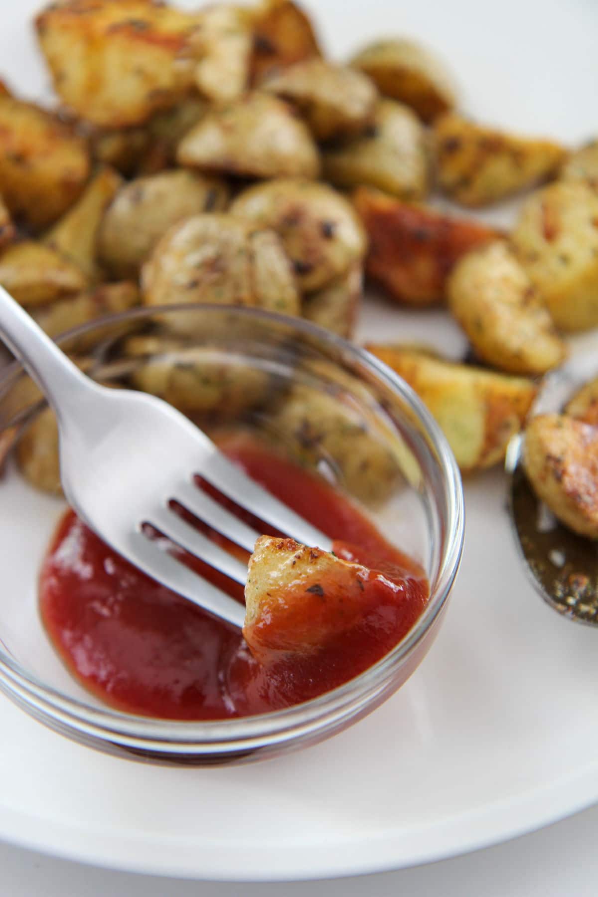 potato dipped in ketchup using a fork 