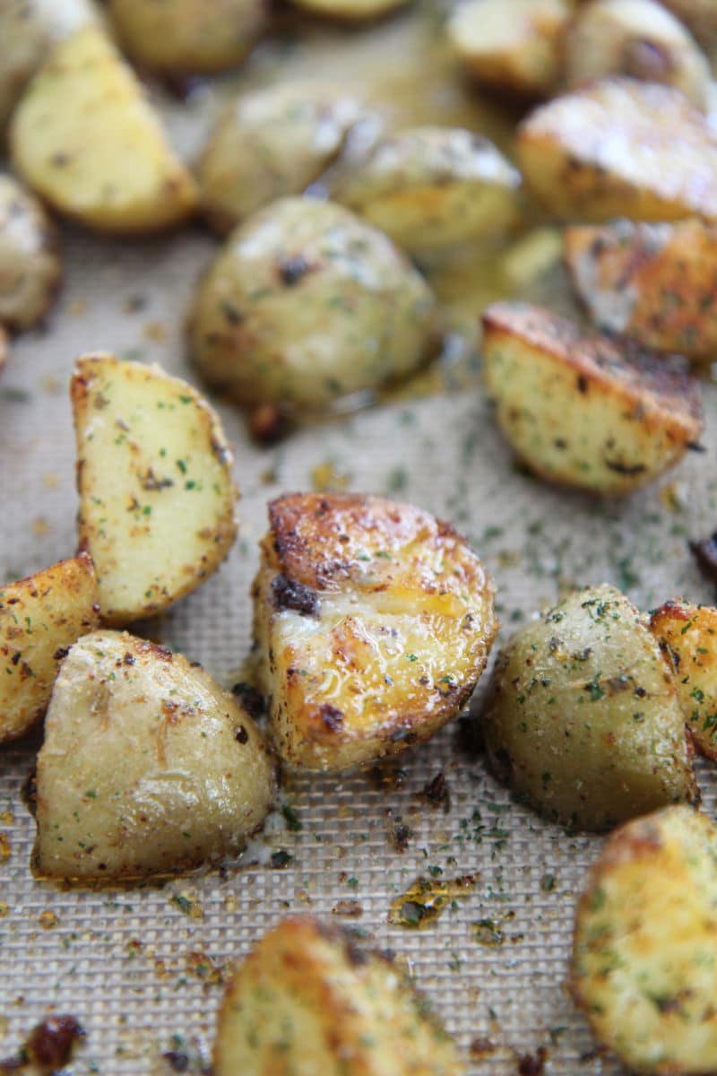 roasted garlic potatoes on a baking sheet up close 