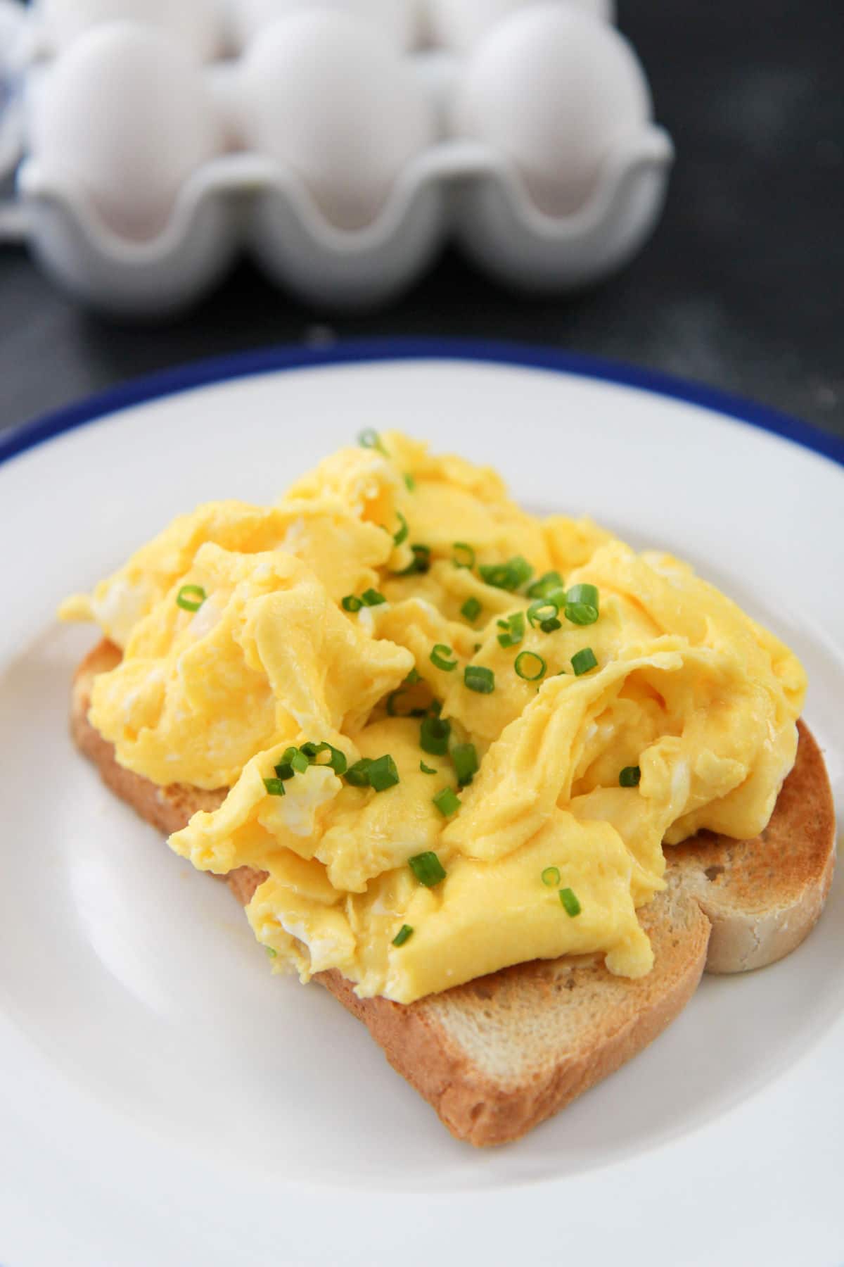  toast on a white and blue plate with eggs in the background 
