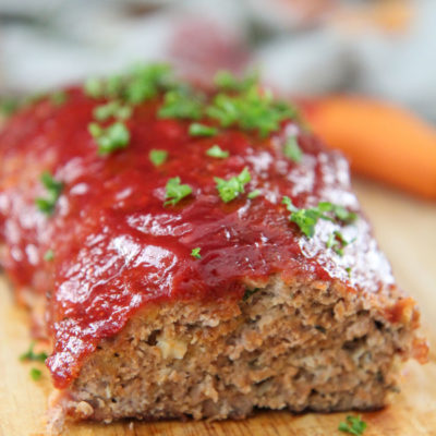 turkey meatloaf with parsley on top on a wooden board
