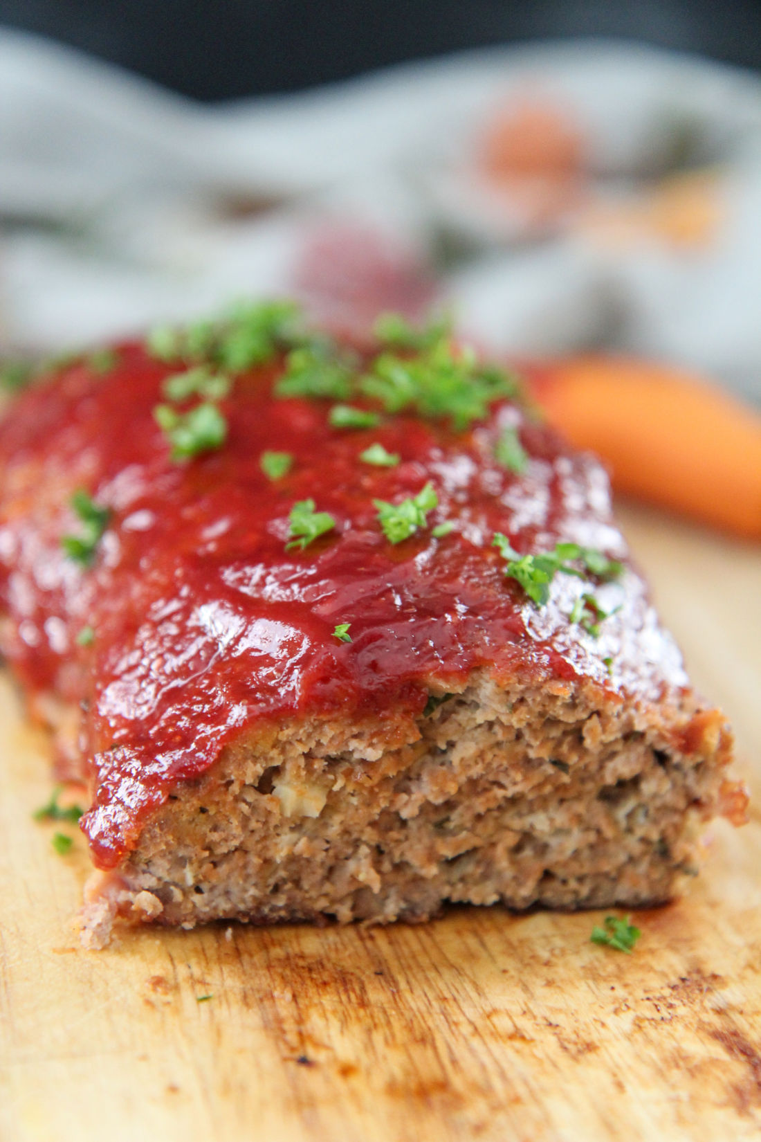 turkey meatloaf with parsley on top on a wooden board 