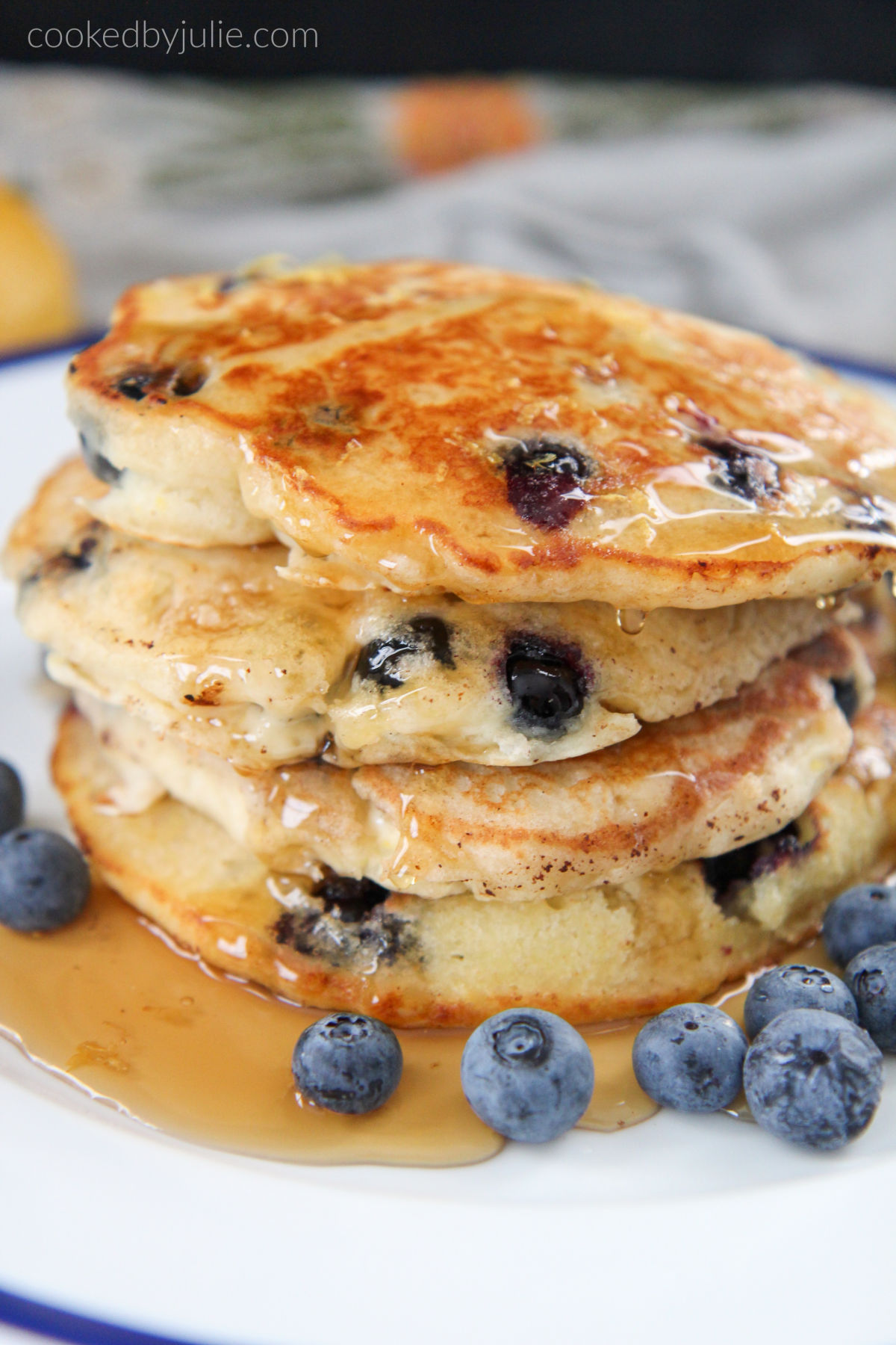 stacked pancakes with syrup and blueberries on the side