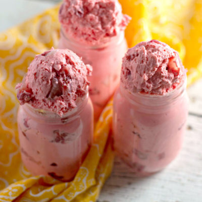 strawberry fat bombs inside mason jars with a yellow towel on the side
