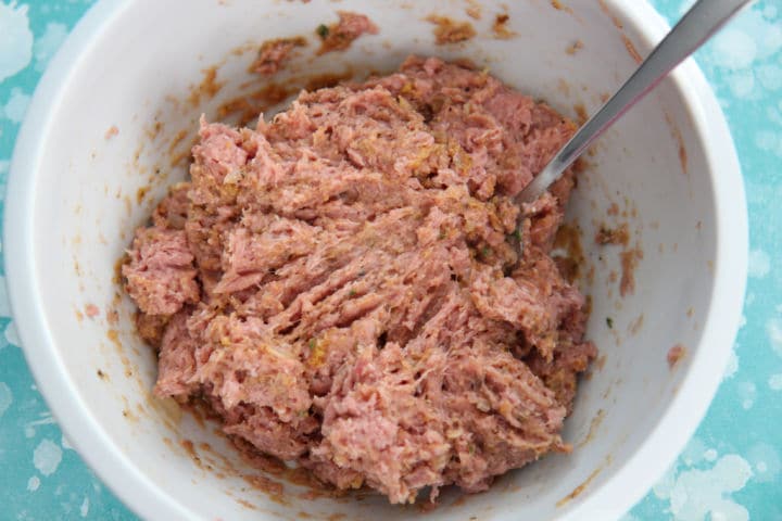 seasoned ground turkey meat in a white bowl with a fork 