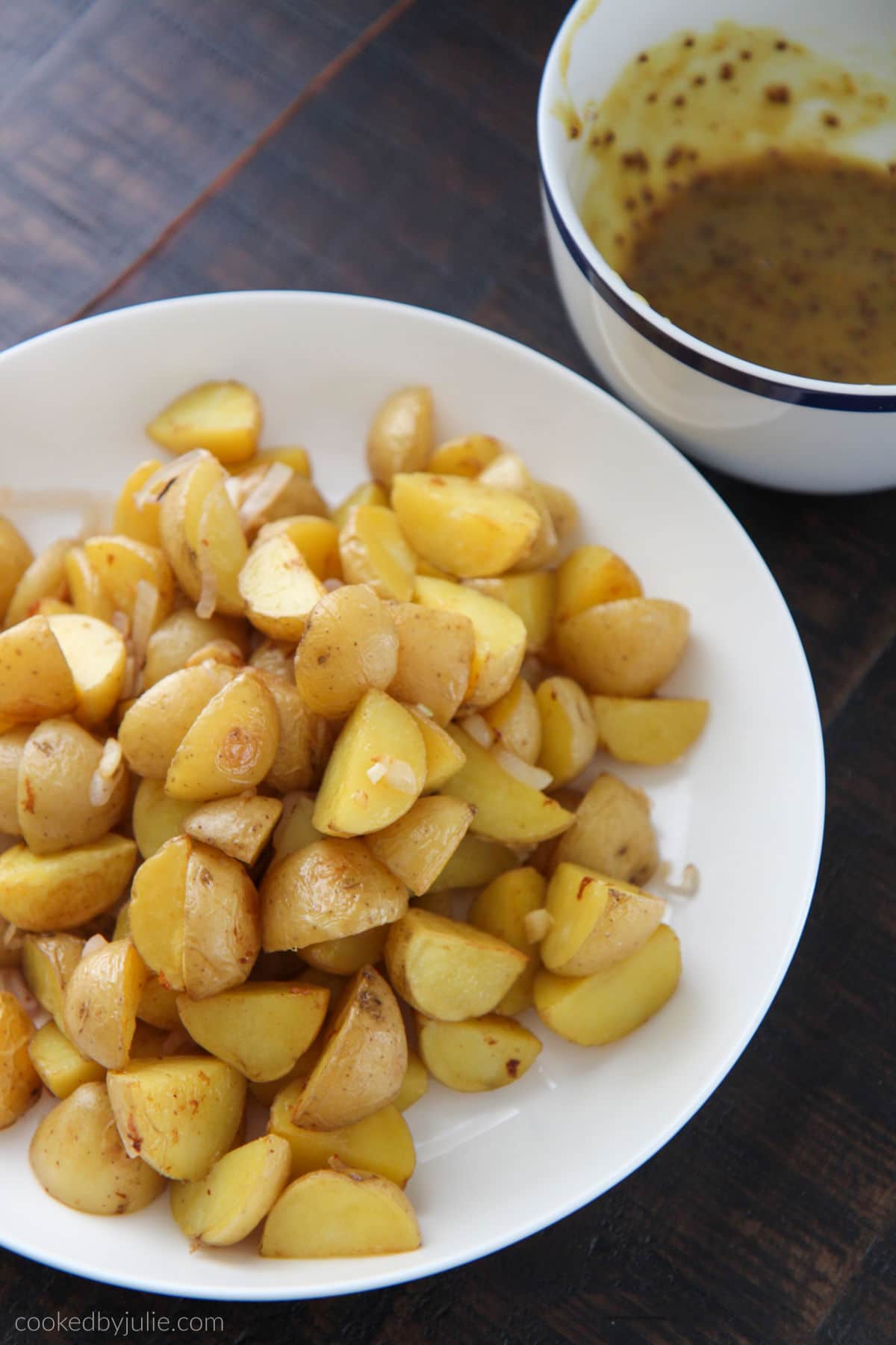 roasted potatoes on a white plate with honey mustard in a small bowl 