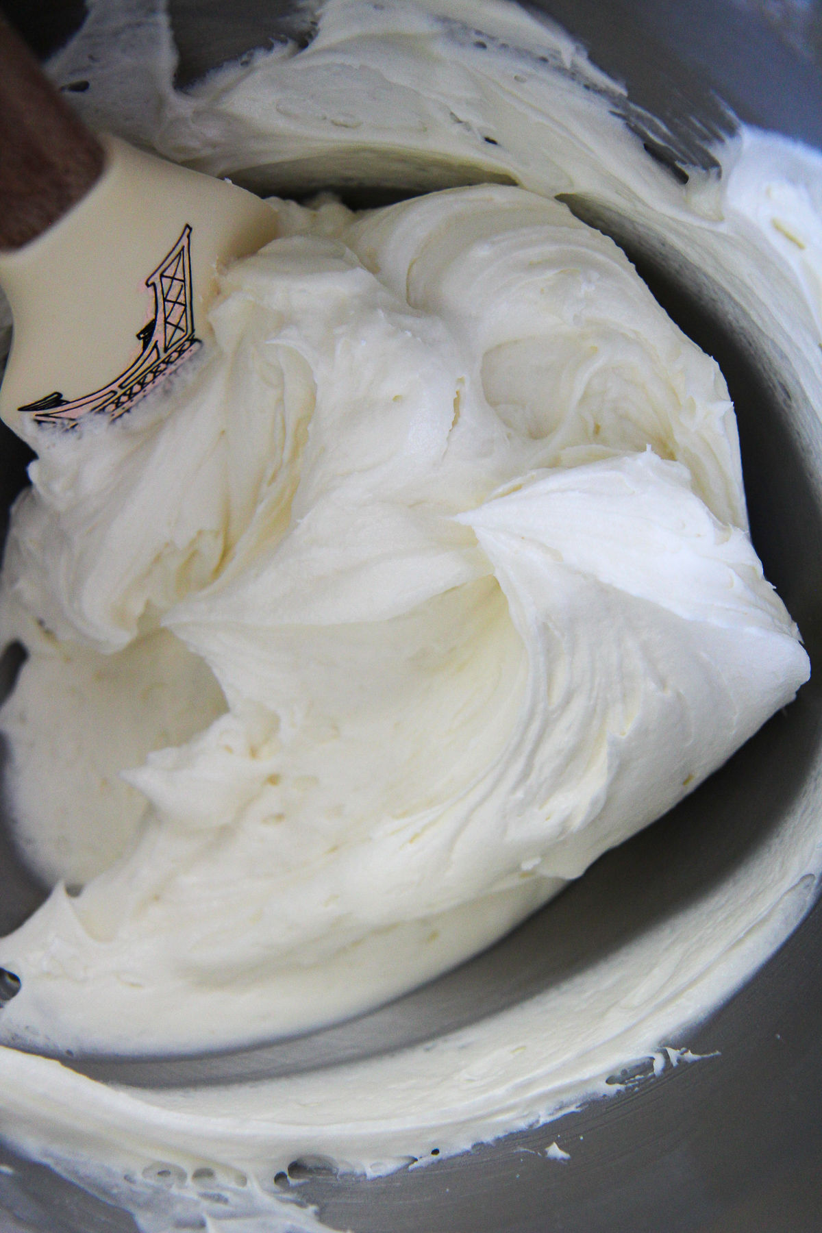 cream cheese frosting in a bowl with a spatula 