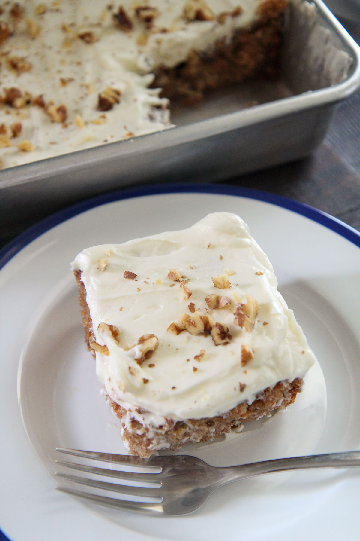 a slice of carrot cake on a white plate with a fork 