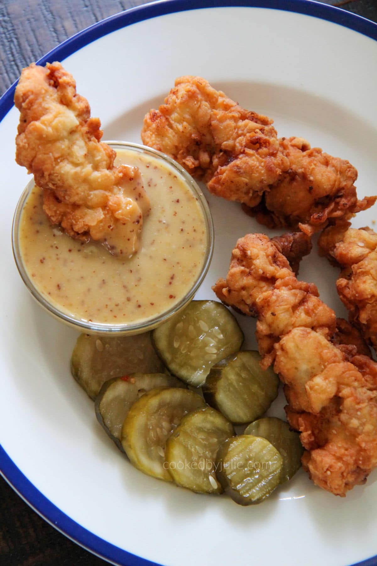 chicken and pickles with sauce on a white plate 