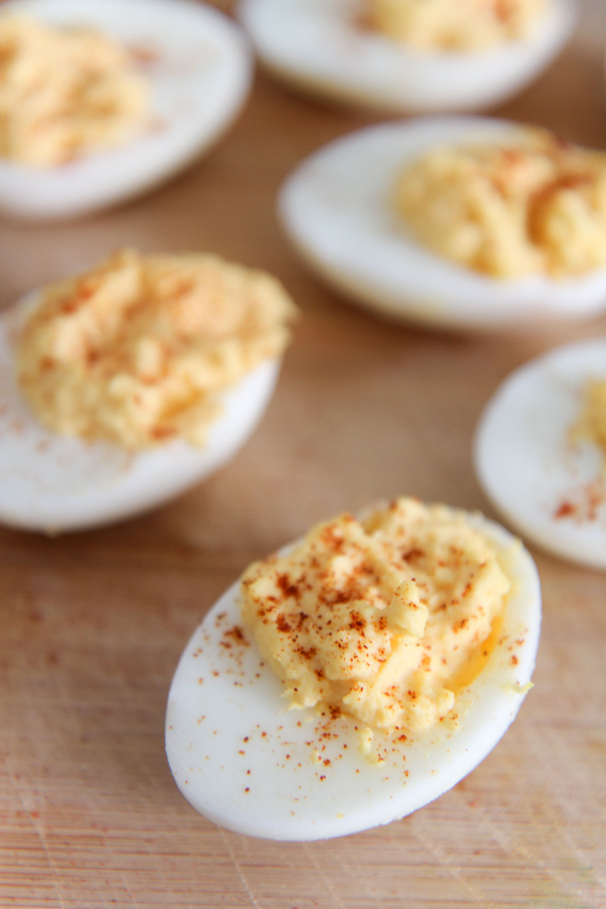 deviled eggs with paprika on a wooden board