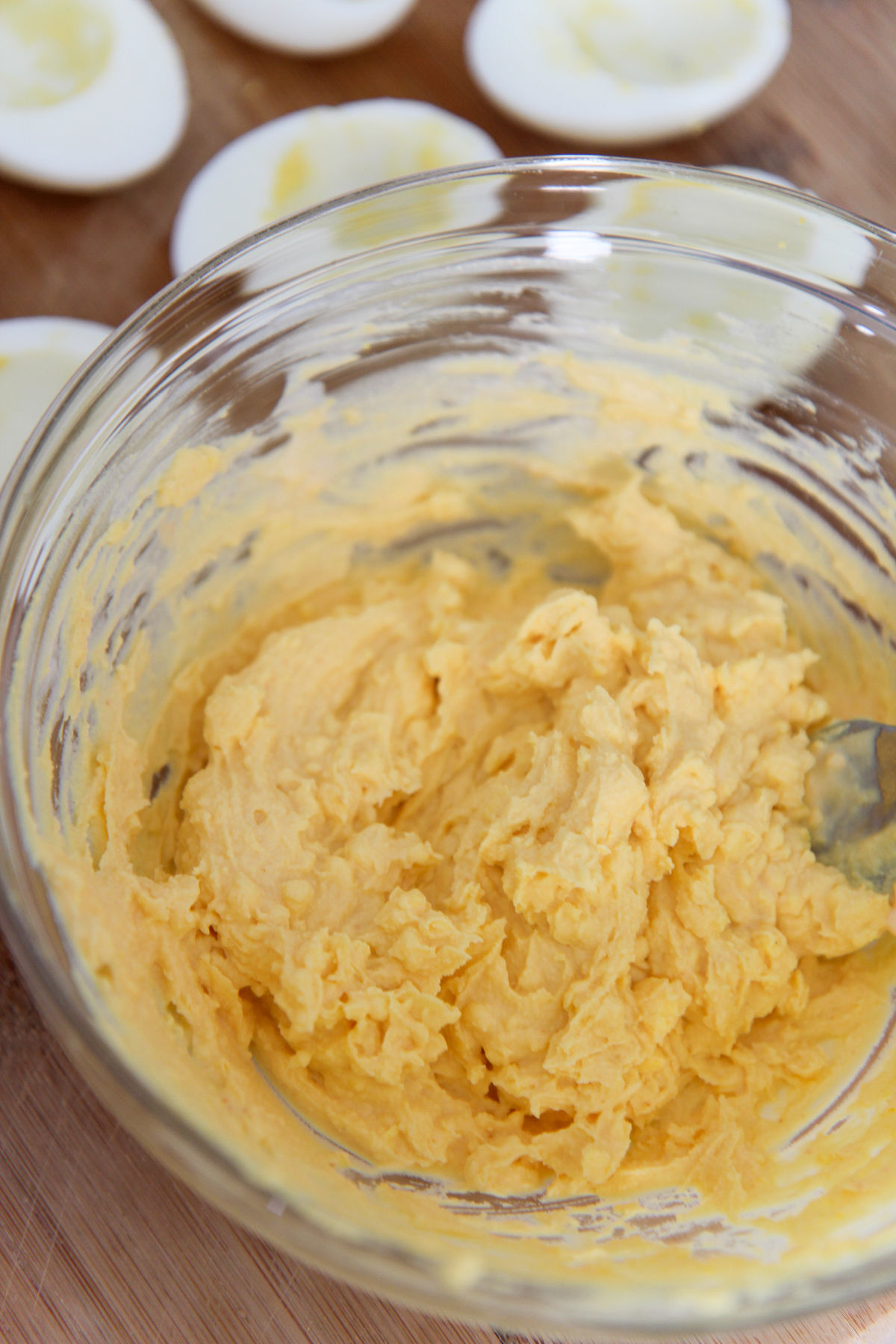 egg yolk mixture in a clear bowl and egg whites in the background 