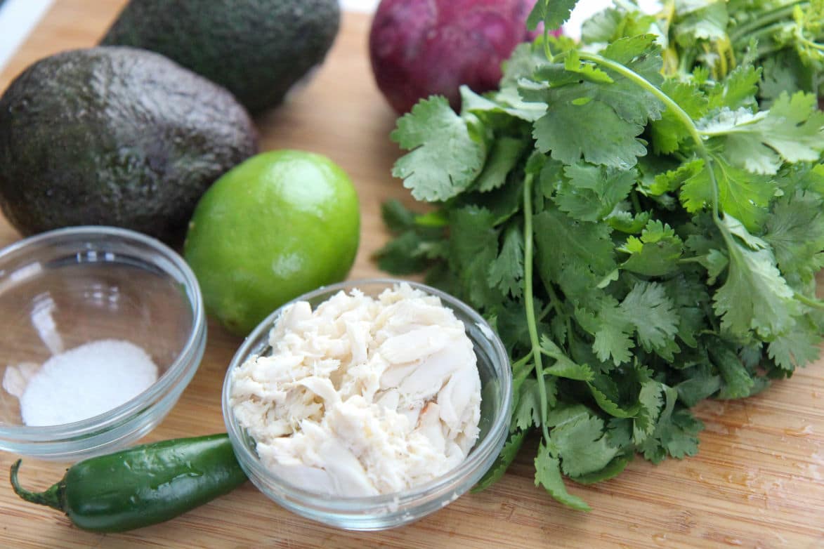 crab and salt in small bowls with cilantro, lime, avocados, and jalapeno 