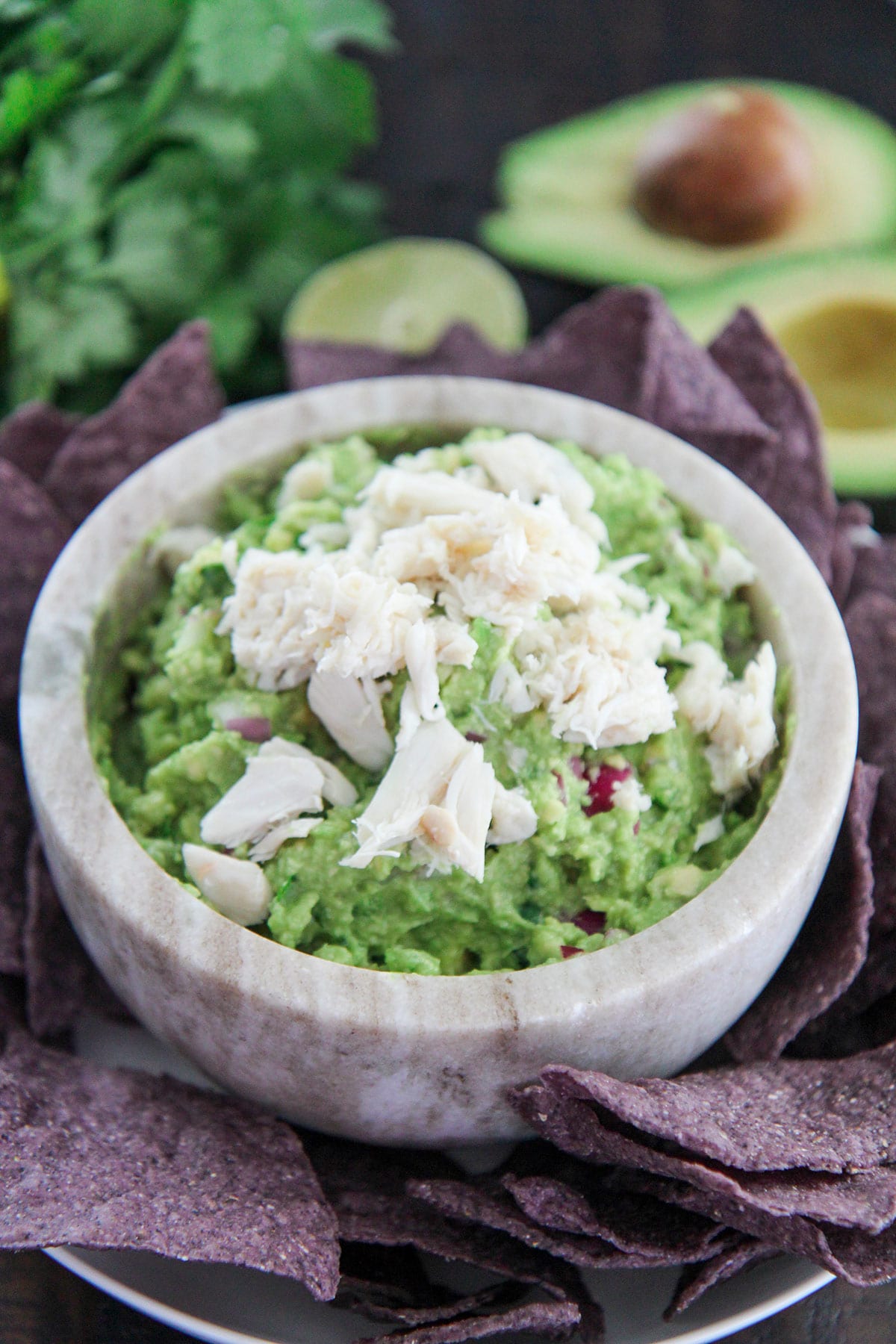 crab guacamole in a bowl with chips on the side