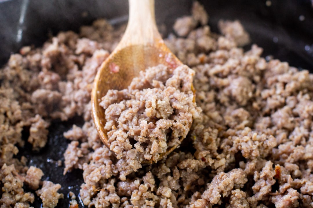 cooked maple breakfast sausage with a wooden spoon