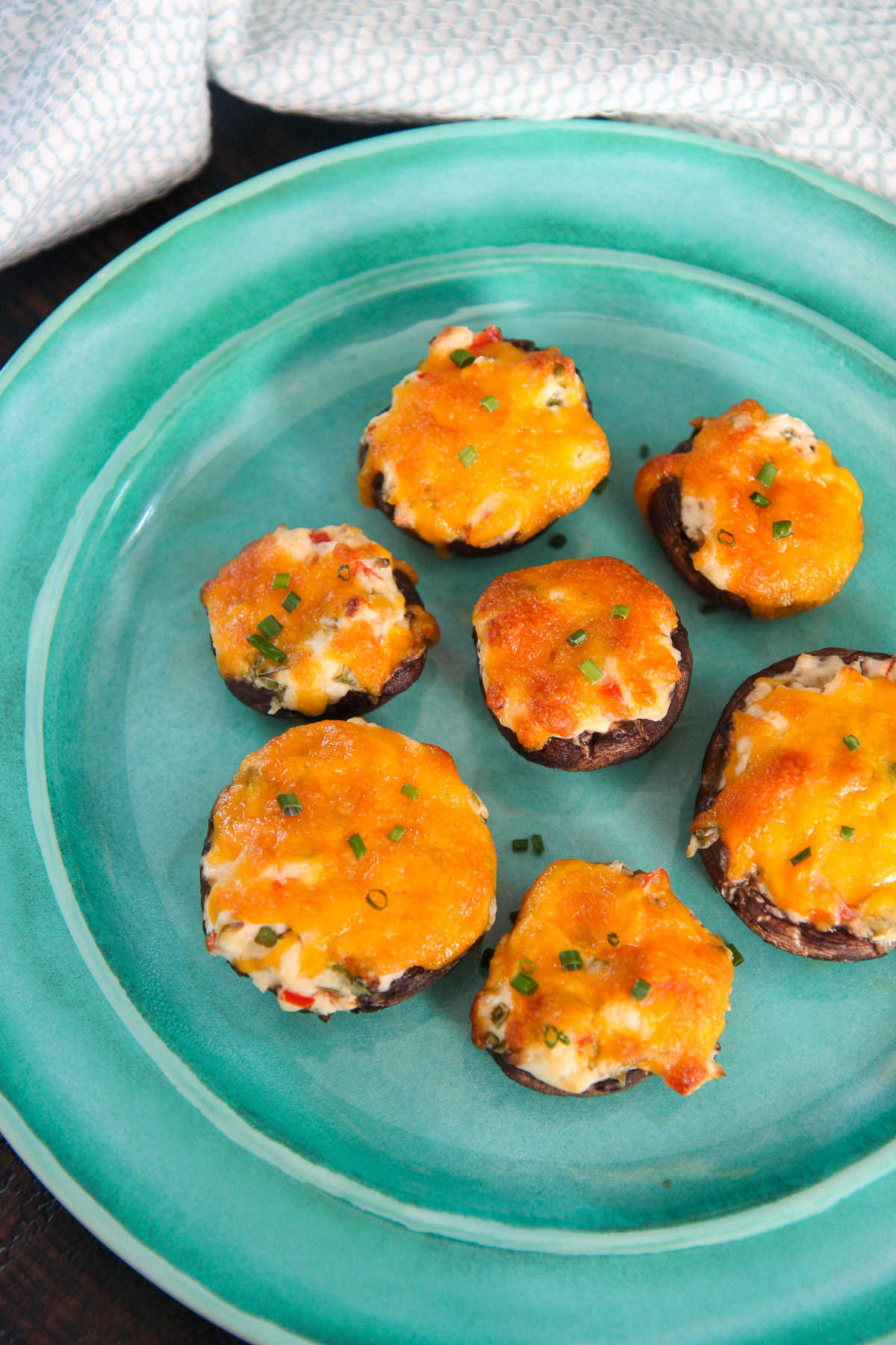 six cheese stuffed mushrooms on a blue plate 