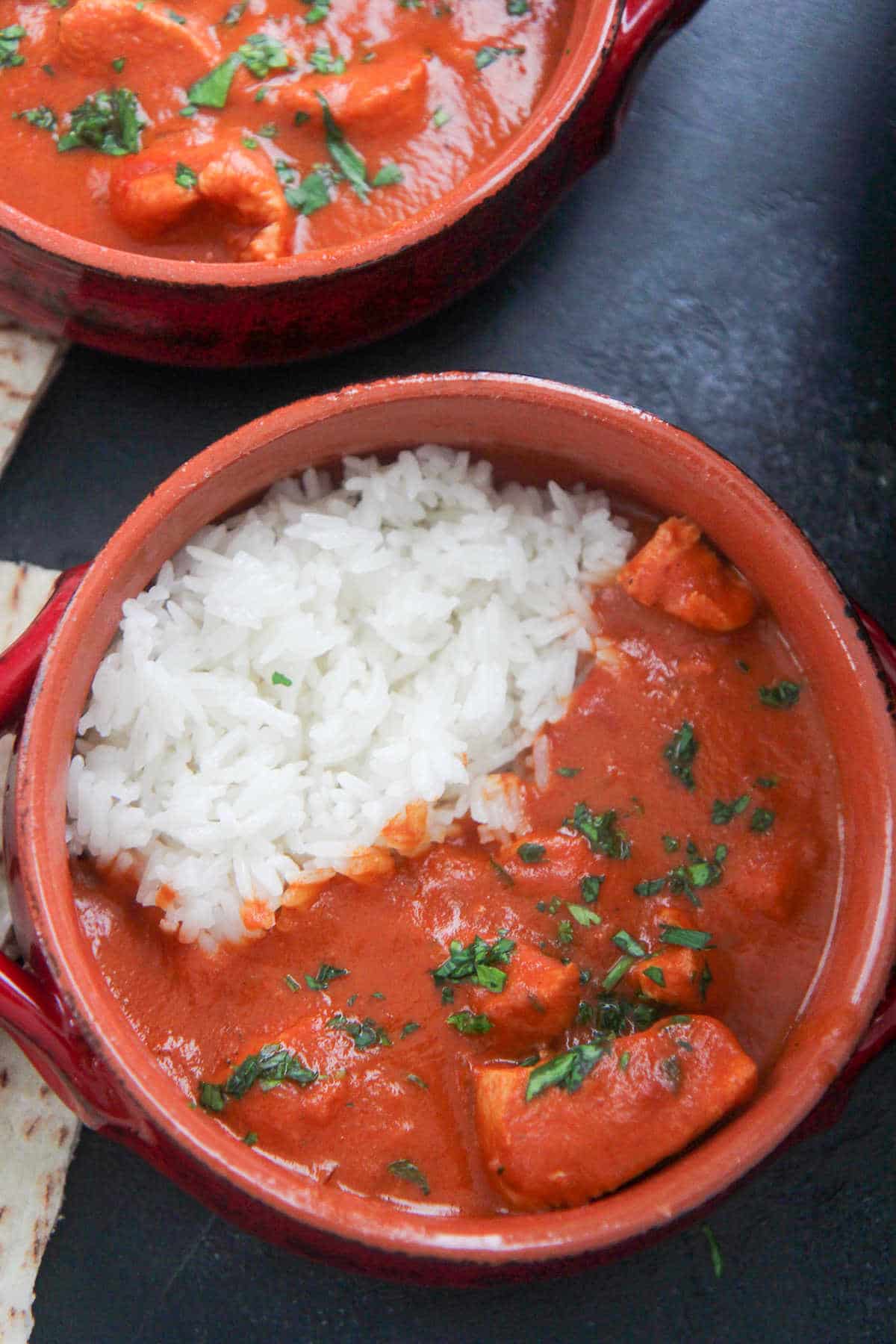 small red bowls with butter chicken and rice 
