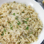 couscous with parmesan cheese and parsley in a white plate