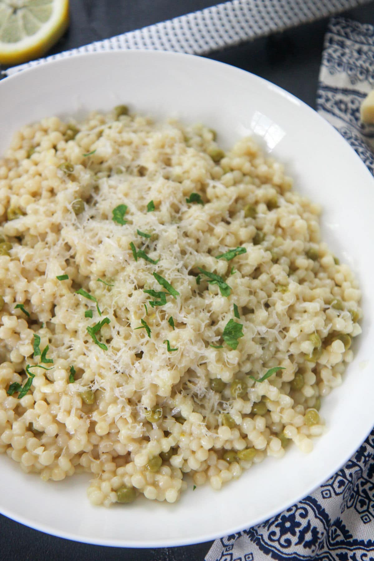 couscous with parmesan cheese and parsley in a white plate 