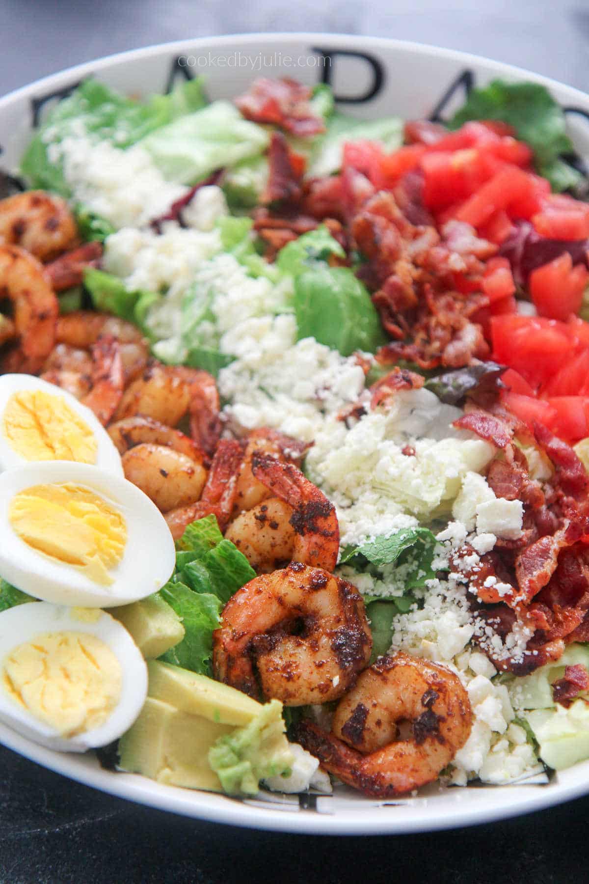 shrimp cobb salad with boiled eggs in a white plate 