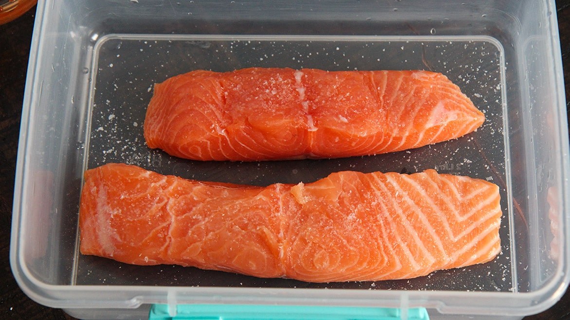 seasoned salmon in a plastic container