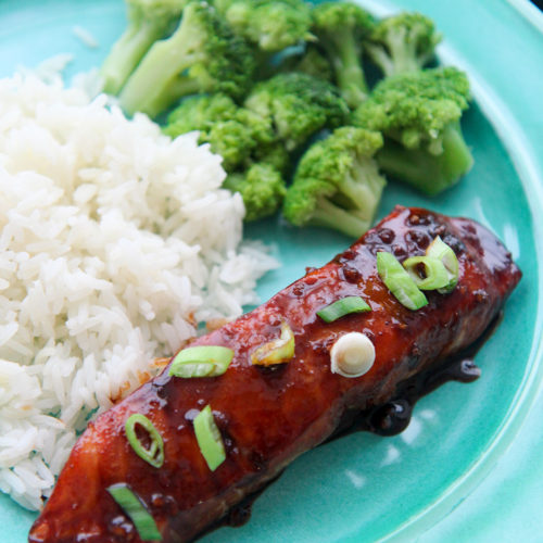 salmon with scallions and rice and broccoli on a blue plate