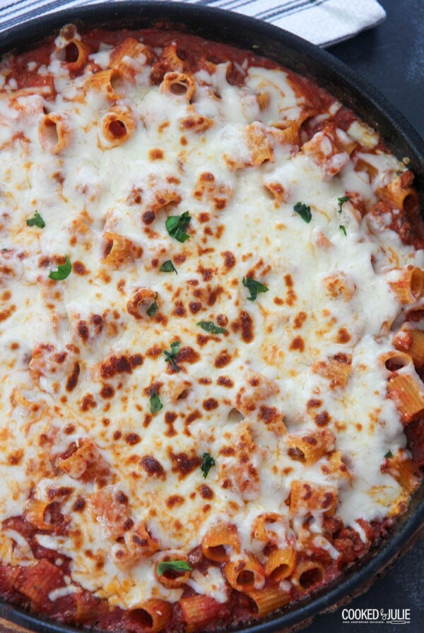 rigatoni with sauce and cheese in a black skillet