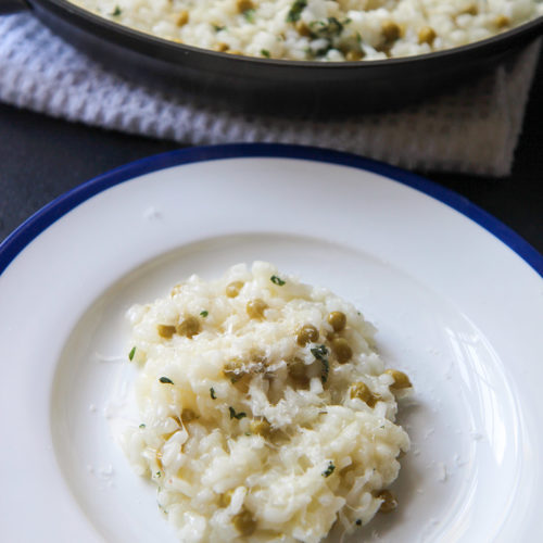 a small plate of cooked arborio ricewith a skillet in the background