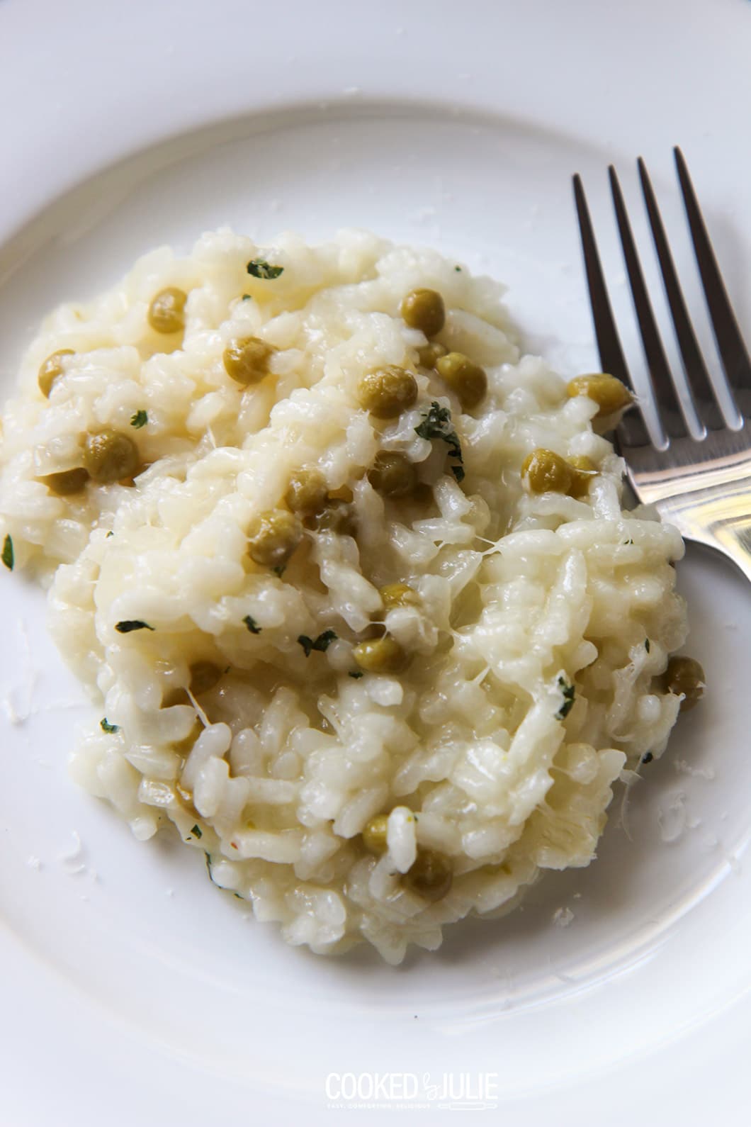 parmesan risotto on a white plate with a fork