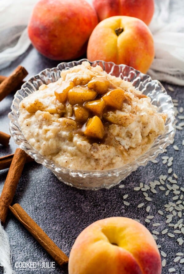 rice pudding and peaches in a glass bowl with peaches on the side