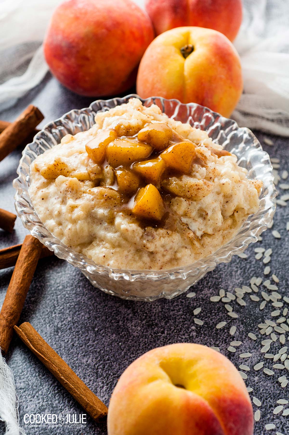 rice pudding and peaches in a glass bowl with peaches on the side 