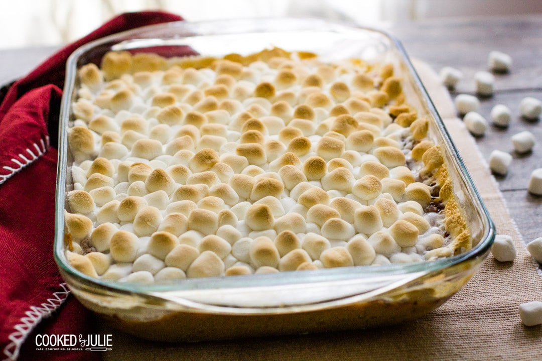 baked mini marshmallows in a glass baking dish with a red towel 