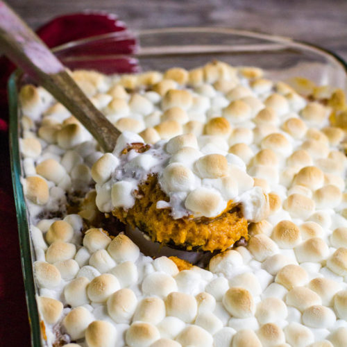 sweet potato casserole in a baking dish with wooden spoon