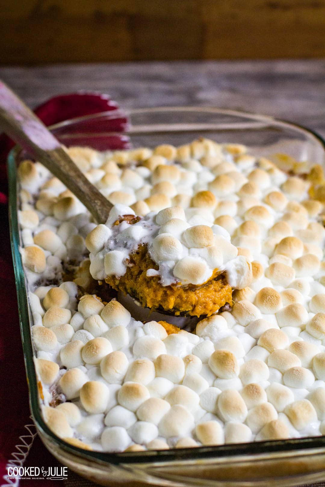 sweet potato casserole in a baking dish with wooden spoon