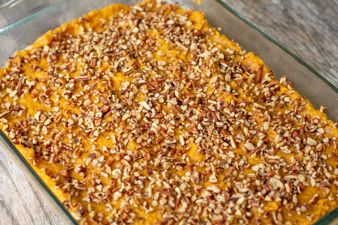 mashed sweet potatoes with pecans in a glass baking dish