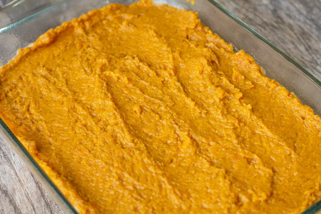 Layered mashed sweet potatoes in a glass baking dish