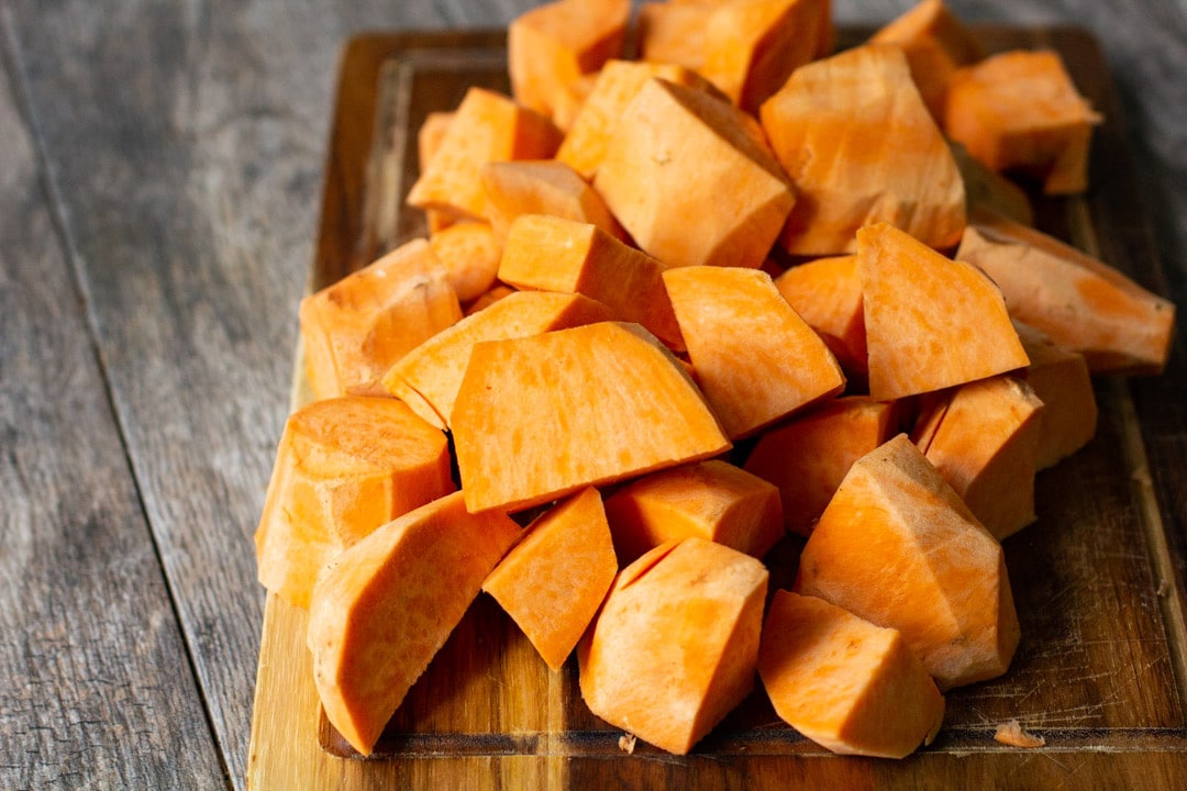 chopped up sweet potatoes on a wooden board