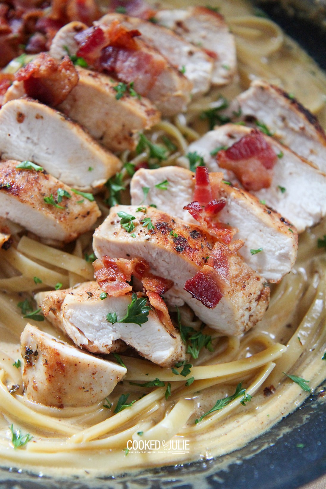 chicken, bacon, and fettuccine in a black skillet 