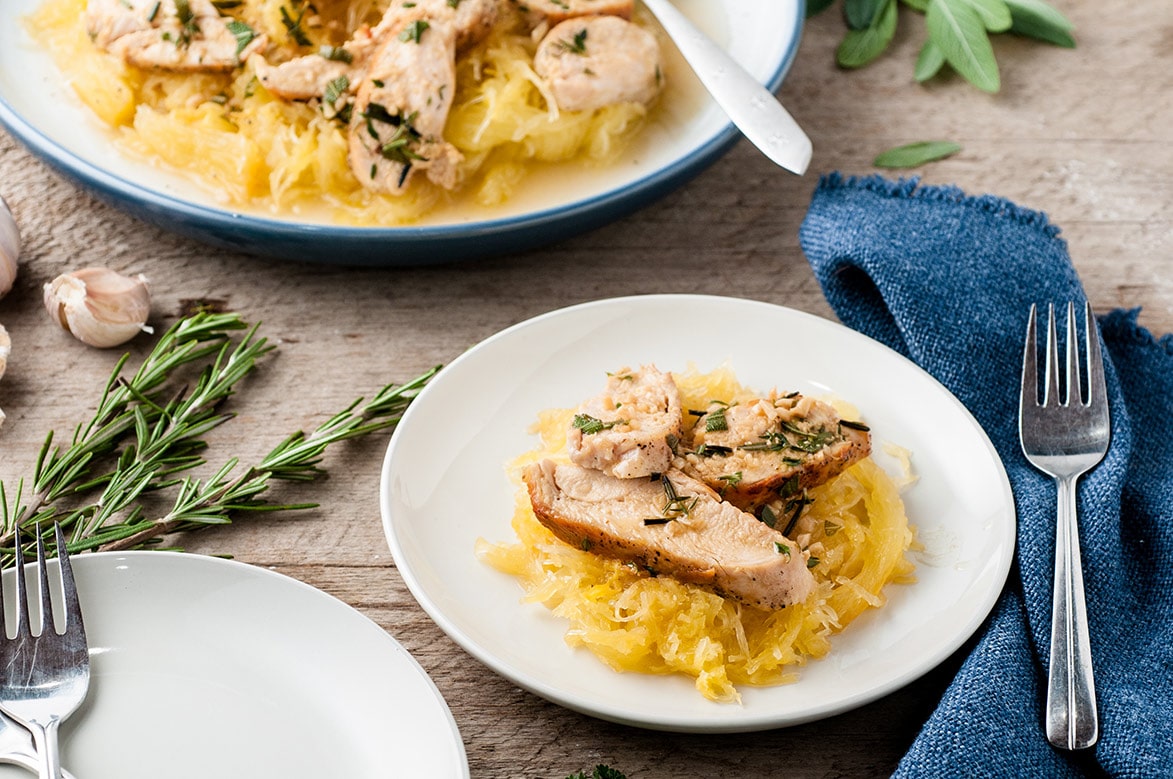 spaghetti squash with garlic chicken on a white plate with a fork