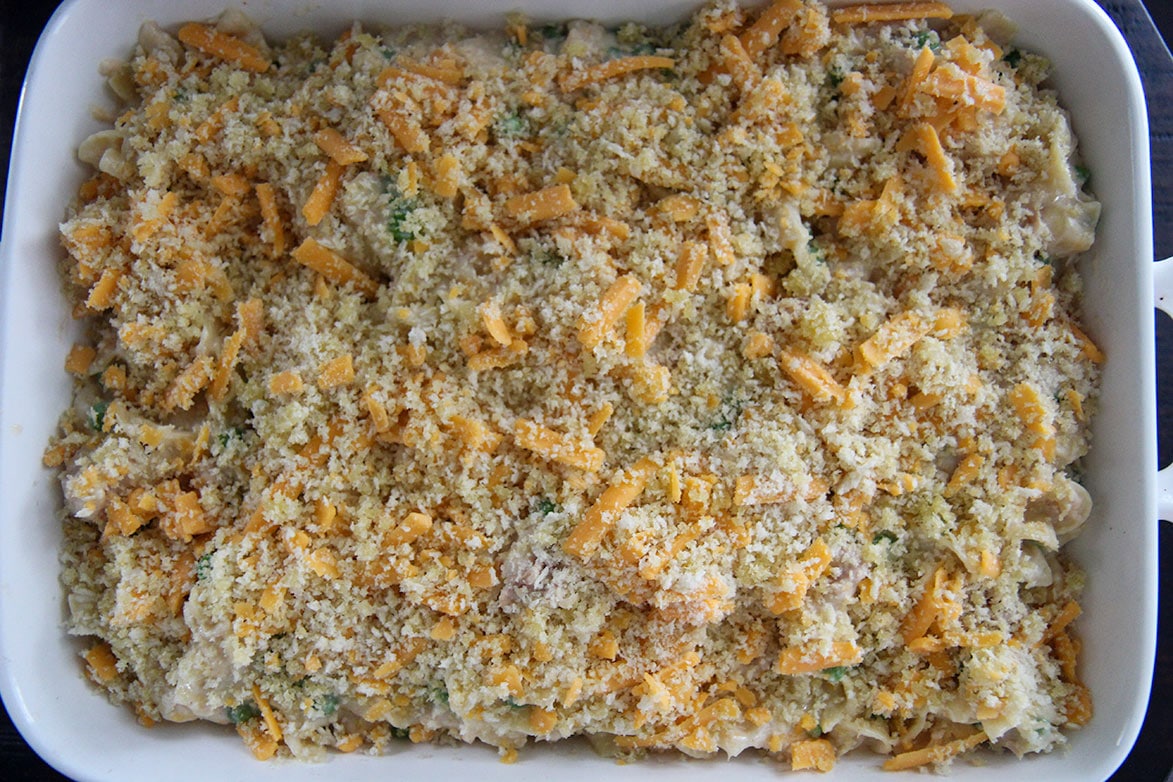 noodles with breadcrumbs and cheese in a white baking dish 